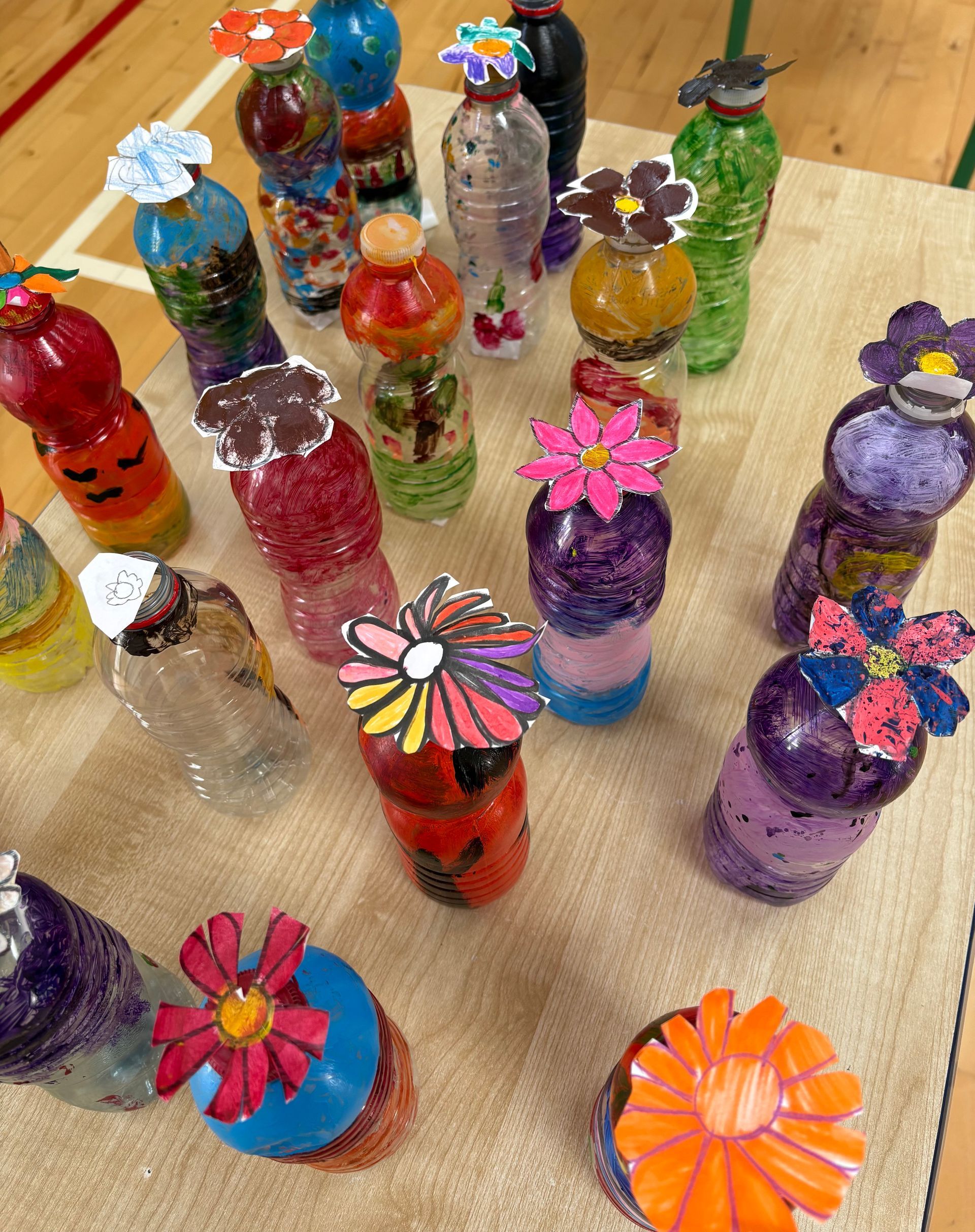 Colorful decorated bottles with flower toppers arranged on a table