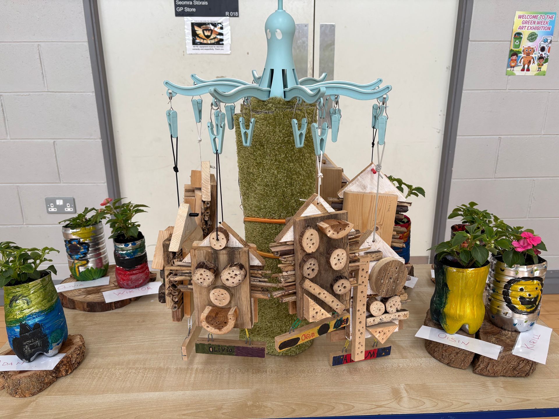 Decorated miniature village display with wood, moss, and a blue fountain centerpiece on a table