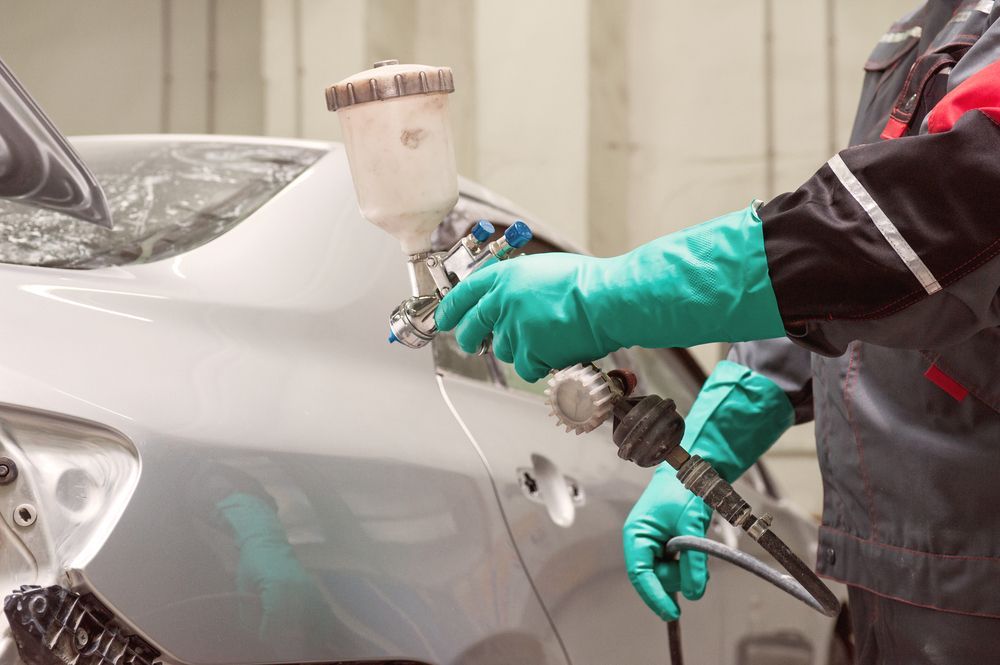 Person in Work Clothes Painting a Car — Mid Coast Smash Repairs In Tuncurry, NSW