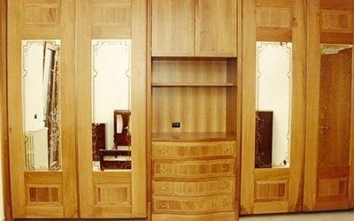 Armadio in legno con ante a specchio e cassetti.
