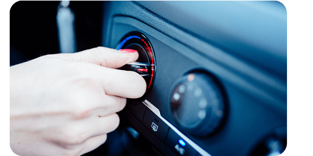 A hand turns a dial in a car's dashboard.