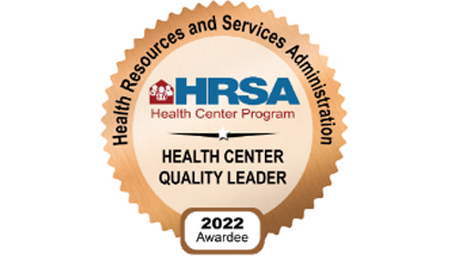 HRSA Health Center Quality Leader 2022 award badge with logo and text in a gold, scalloped-edge seal.