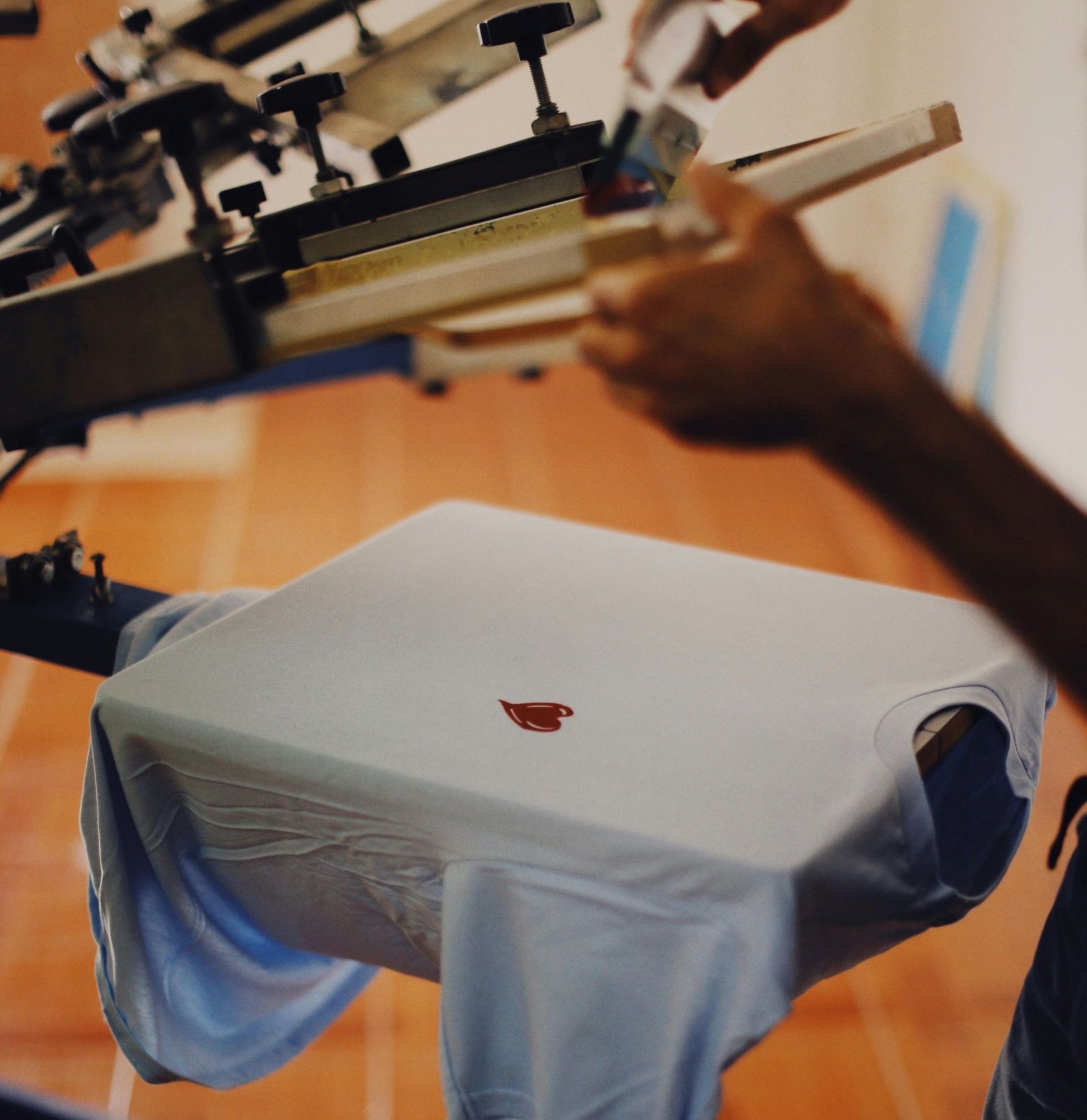 Demonstration of a t-shirt printing method, showing the process of applying a design onto fabric using specialized equipment. Demonstration of a t-shirt printing method, showing the process of applying a design onto fabric using specialized equipment.