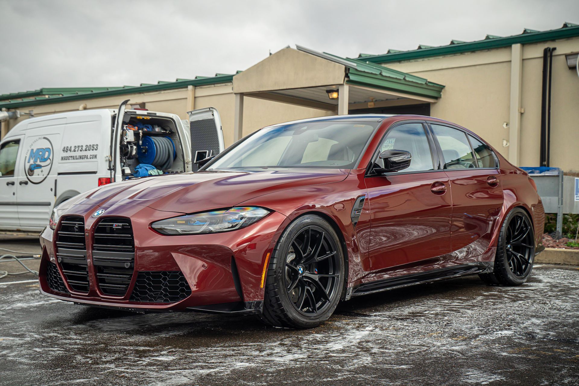 A red bmw m3 is parked in front of a building.