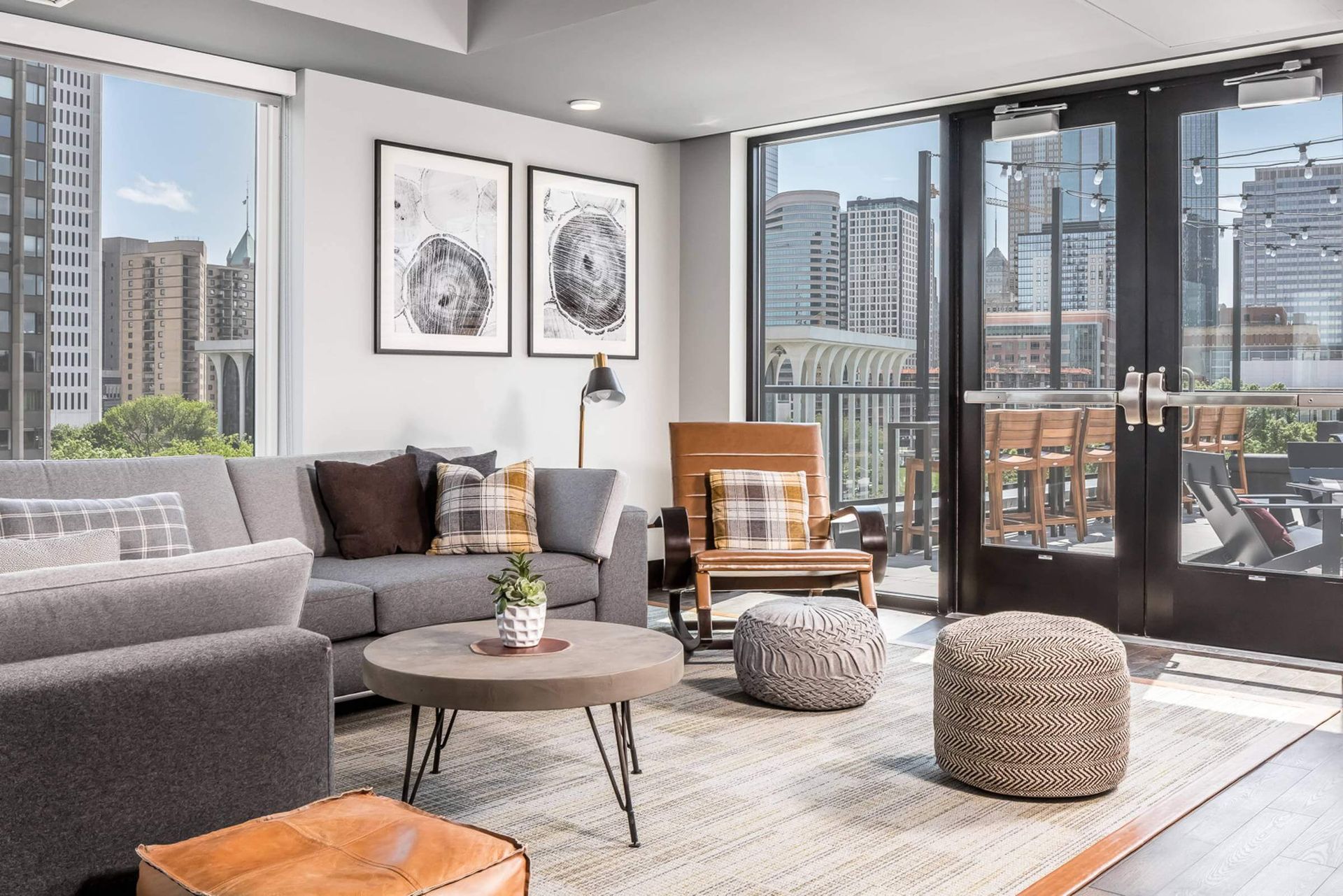 A living room with a couch , chair , coffee table and ottomans.