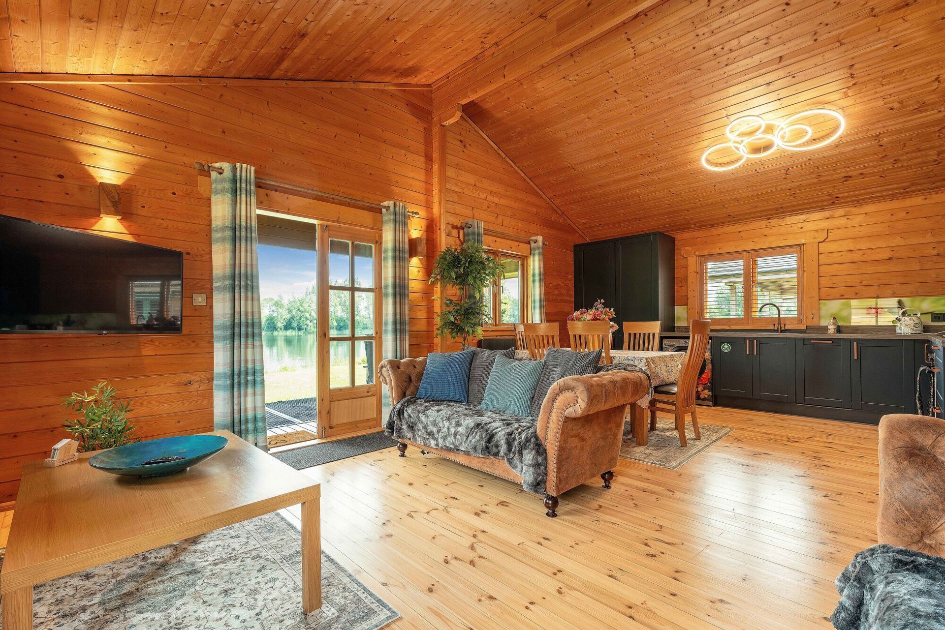 Open-plan living area with lake views at Lodge 5 Heron