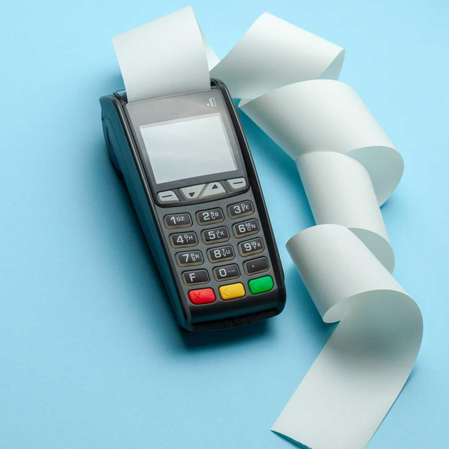 Card payment terminal with receipt paper curling out on a blue background
