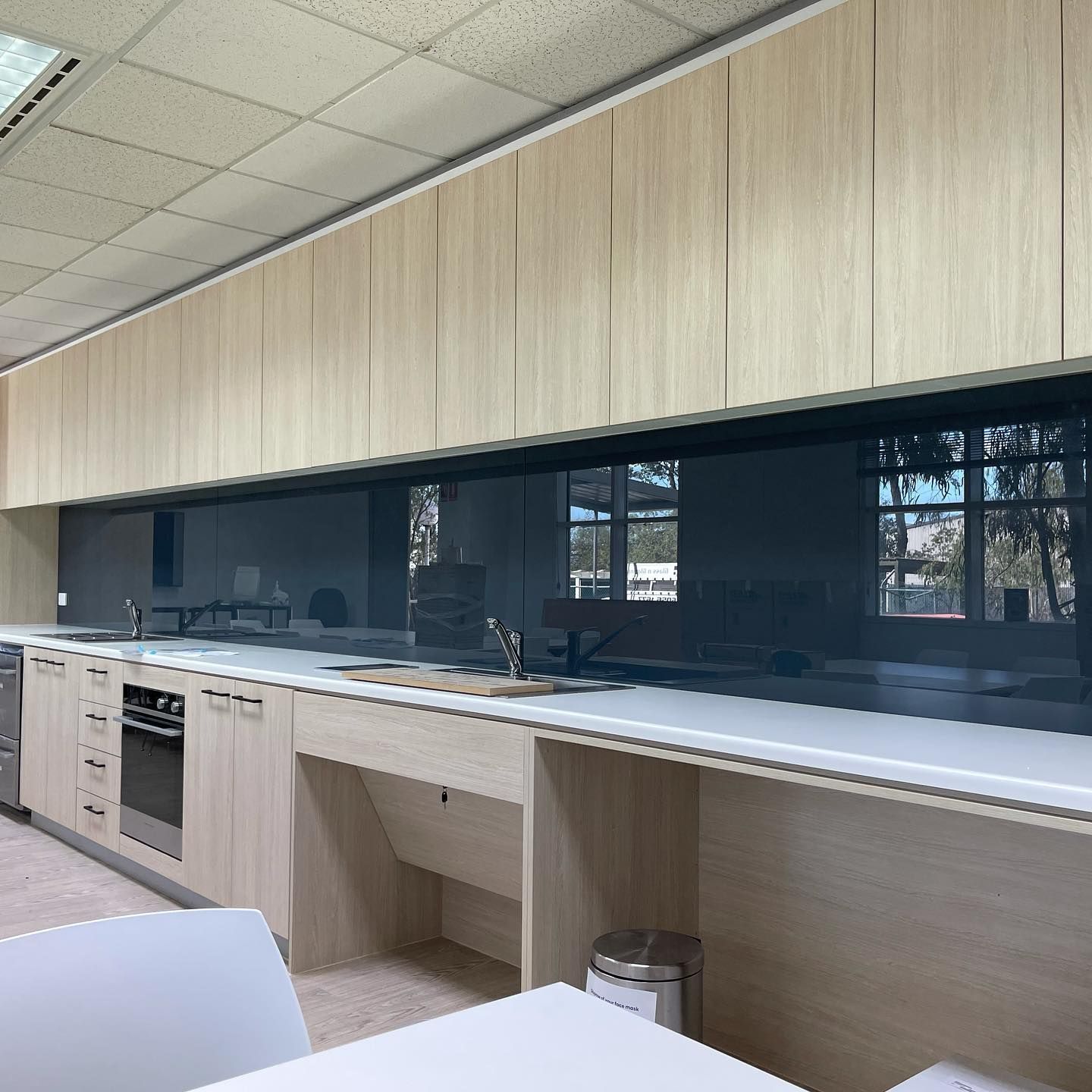 A Kitchen with Wooden Cabinets and White Counter Tops — Lock & Door in Wodonga, VIC