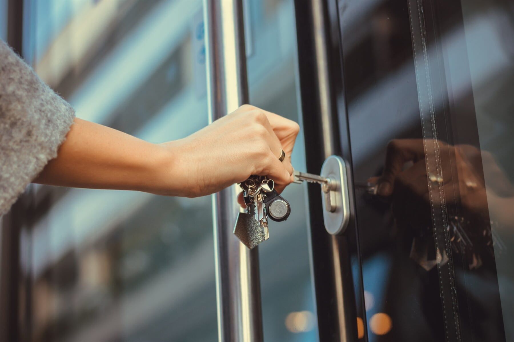 A Woman Is Opening a Door with A Key — Lock & Door in Wodonga, VIC