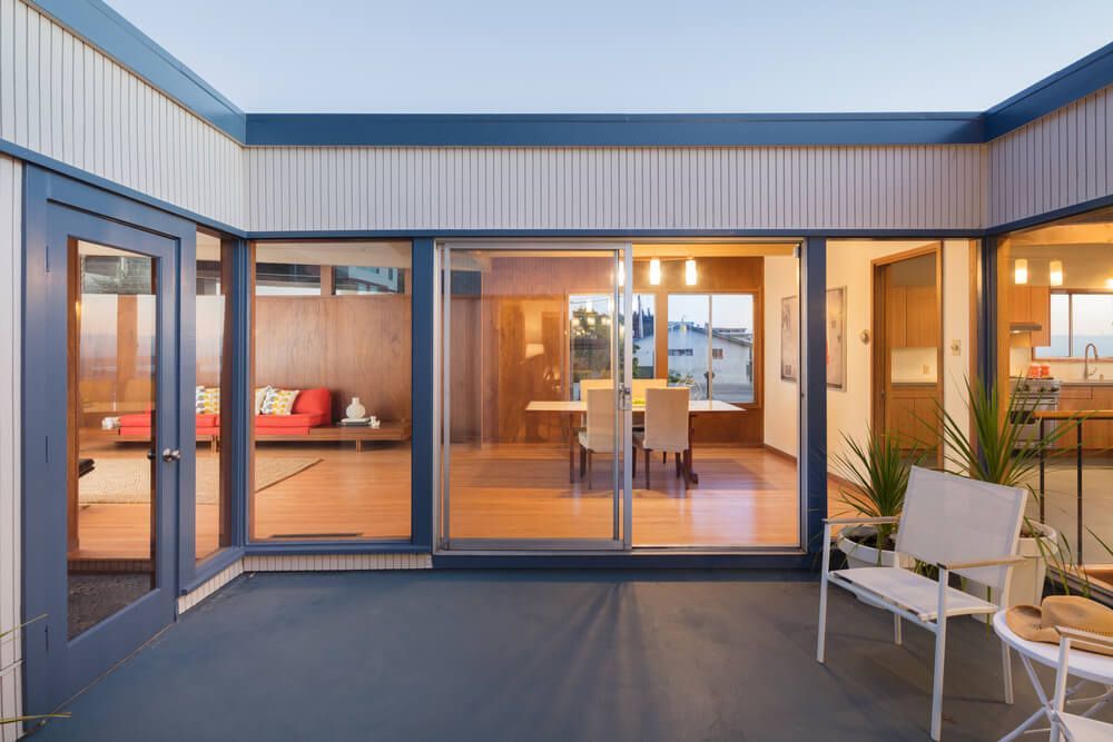 A Patio with A Bench and Chairs in Front of A House with Sliding Glass Doors — Lock & Door in Albury, NSW