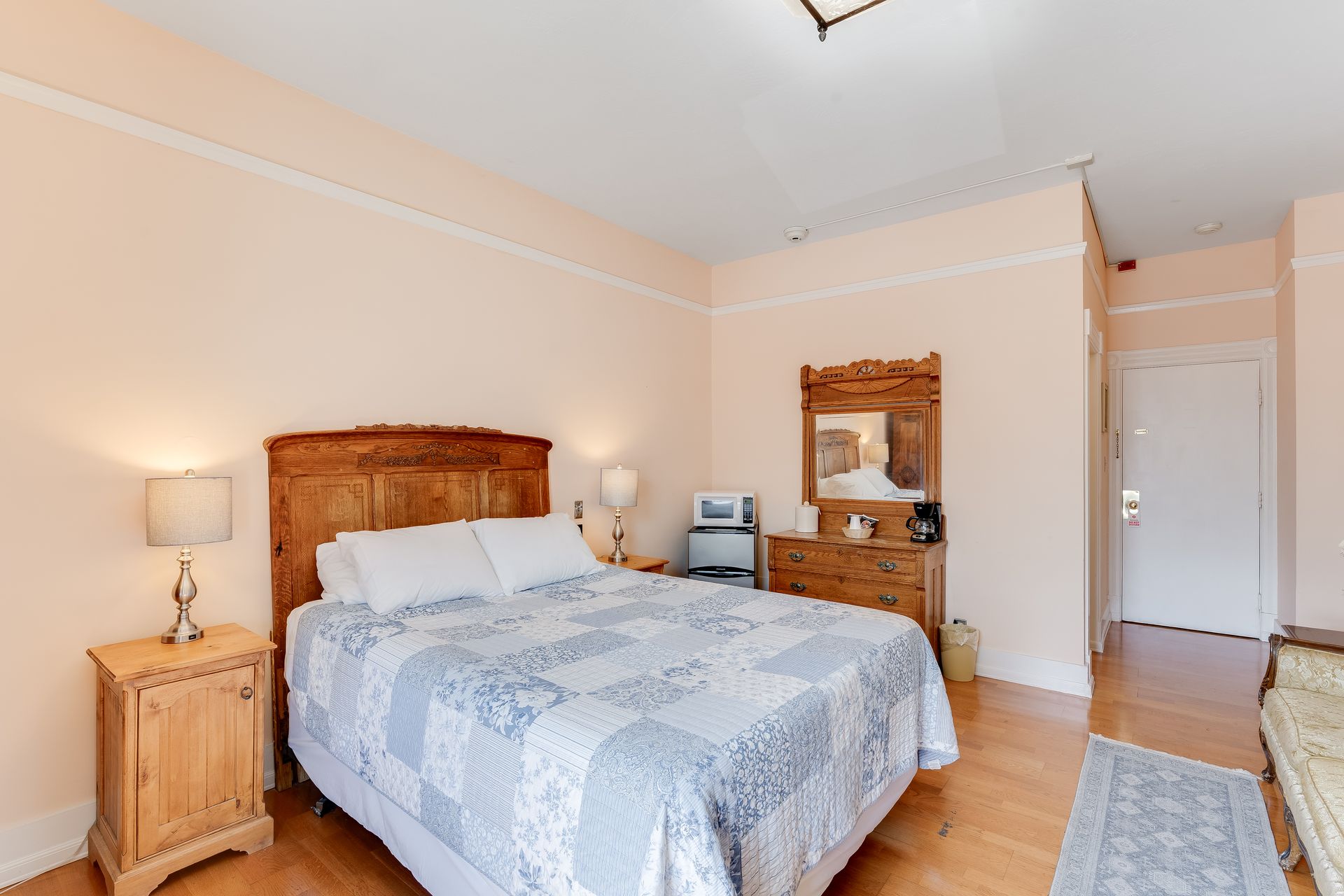 Bedroom with bed, dresser, nightstand, and beige walls.