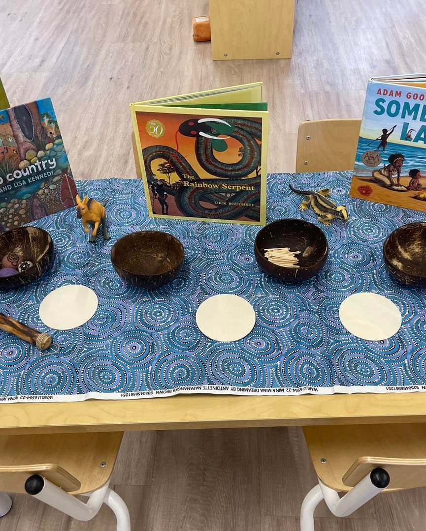 Tabletop display with books, coconut bowls, and toy animals.