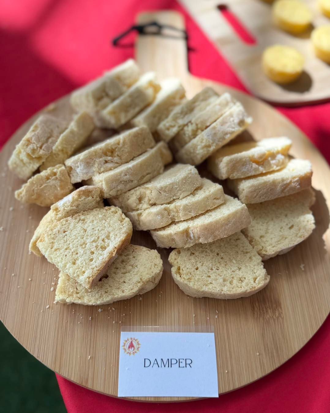 Sliced damper bread on a wooden board with a label.