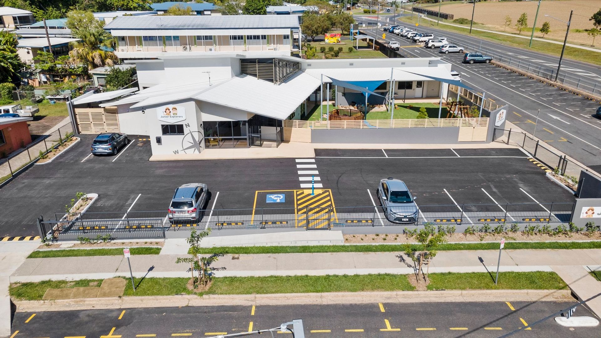 Exterior view of a building with a parking lot. A few cars are parked. Wheelchair-accessible parking is available.