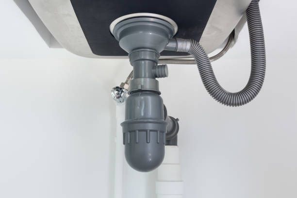 A close up of a sink drain with a hose attached to it.