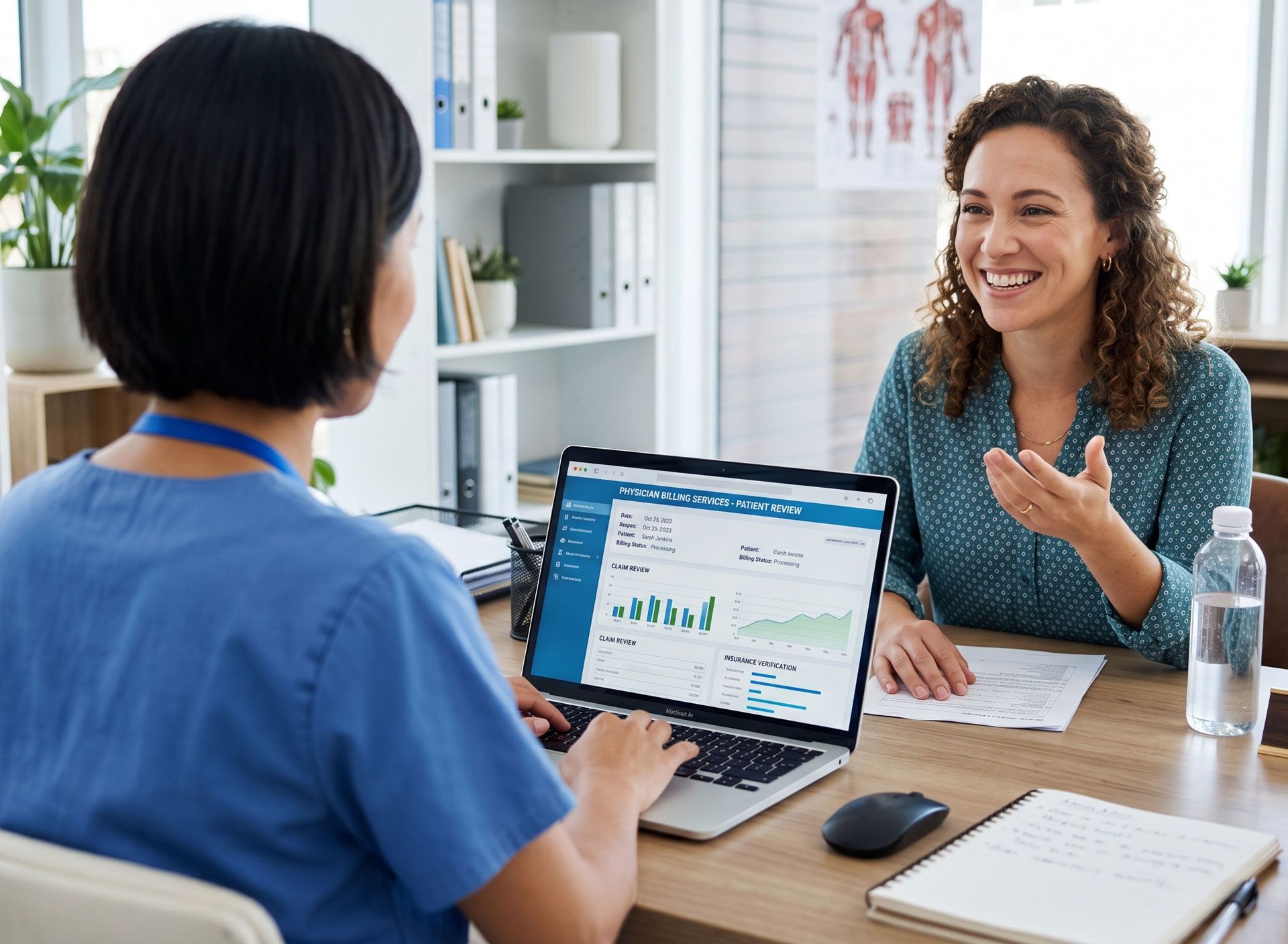 Two women in a clinic discuss health charts across a desk with a laptop and papers