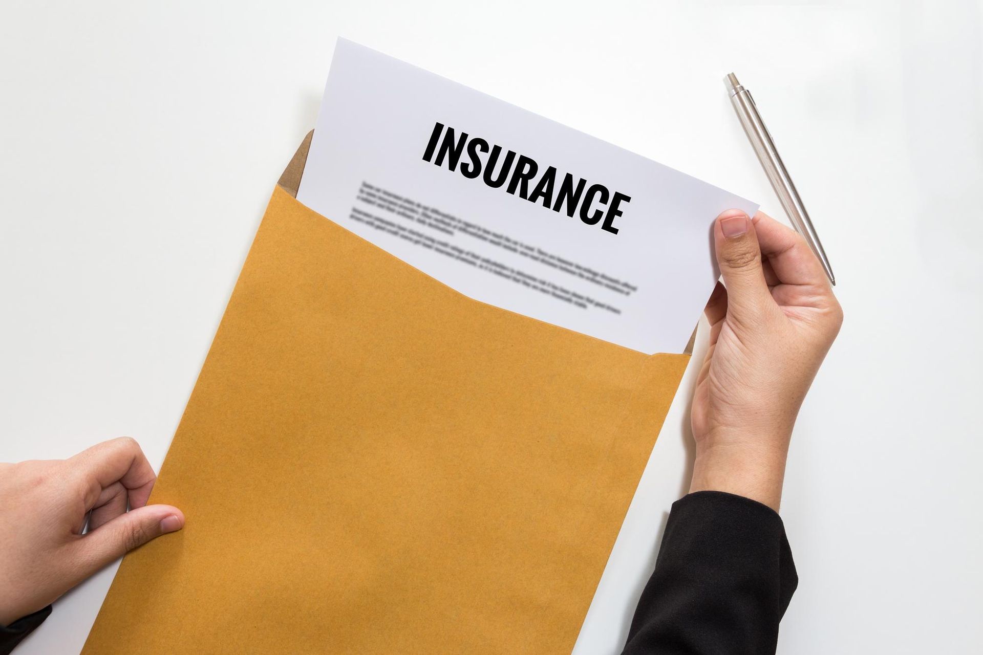 A person is holding an envelope with a piece of paper in it that says `` insurance ''.