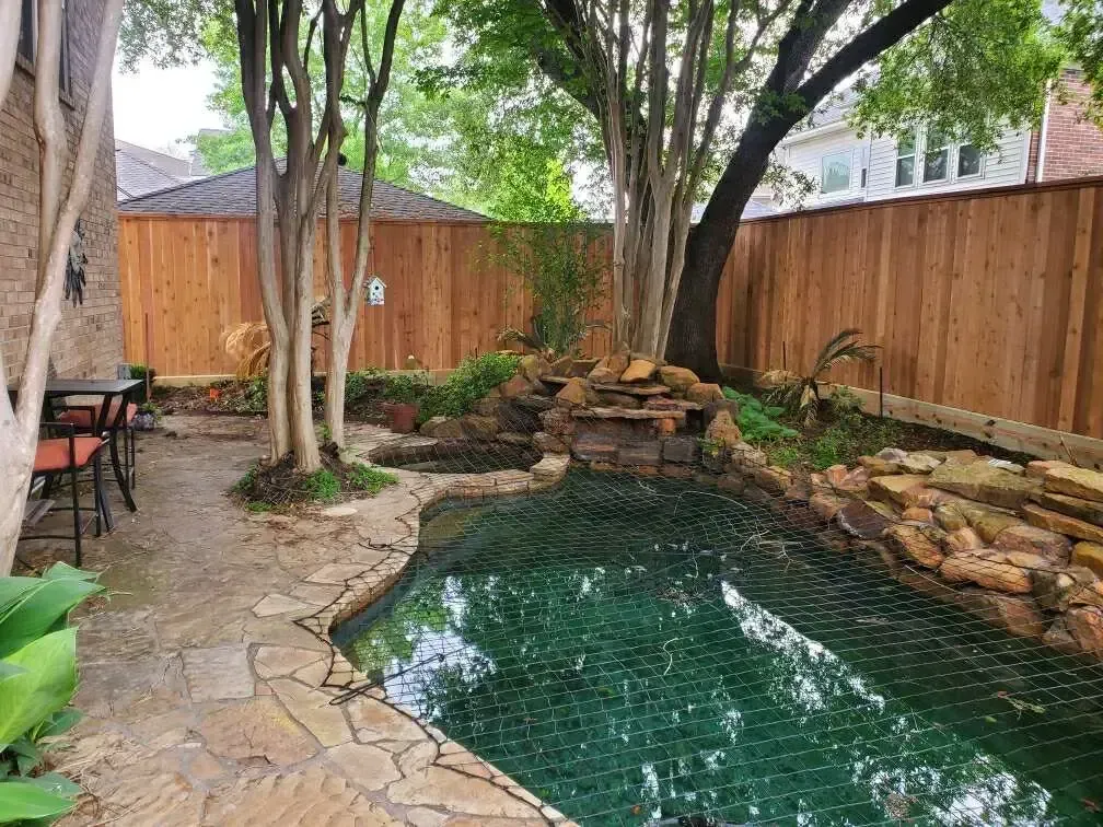 A backyard with a pool and a wooden fence