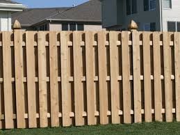 A wooden fence with a gate in the backyard of a house.
