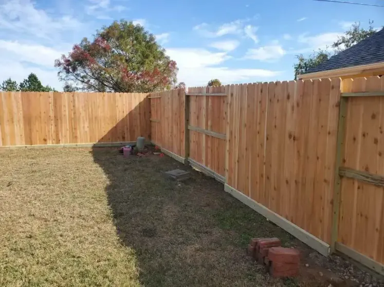 A wooden fence is sitting in the middle of a grassy yard.
