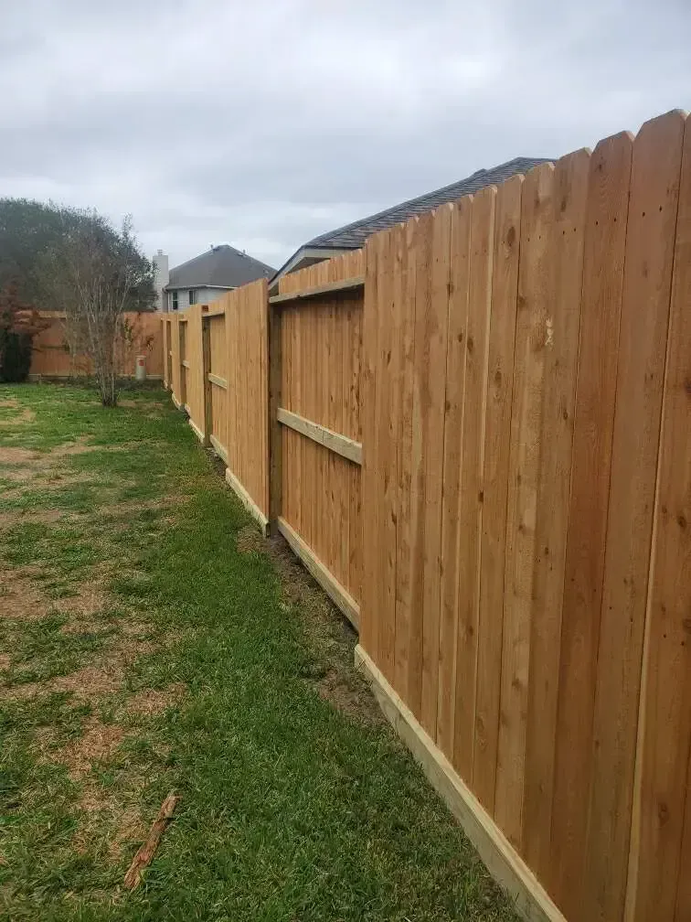 A wooden fence is sitting in the middle of a grassy field.