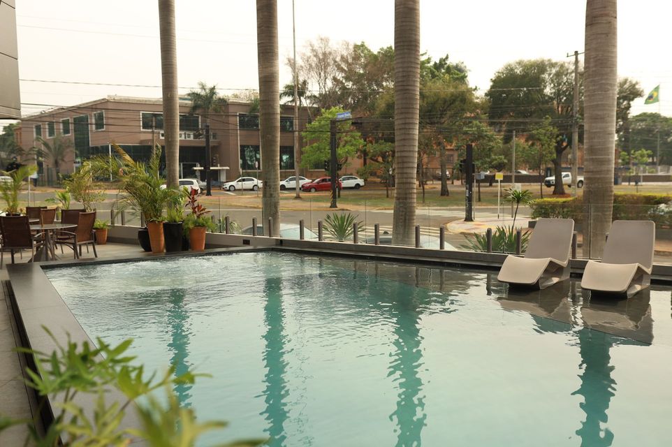Hotel com fachada laranja e cinza ao entardecer.