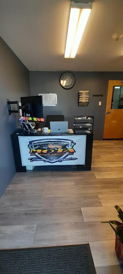 A room with a desk and a clock on the wall.