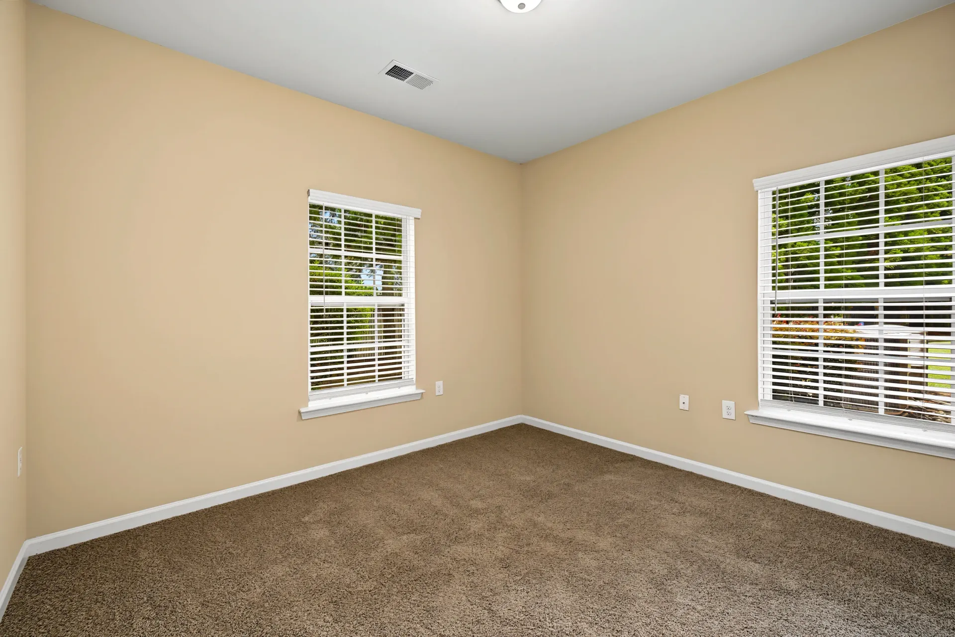 Empty room with two windows and neutral walls