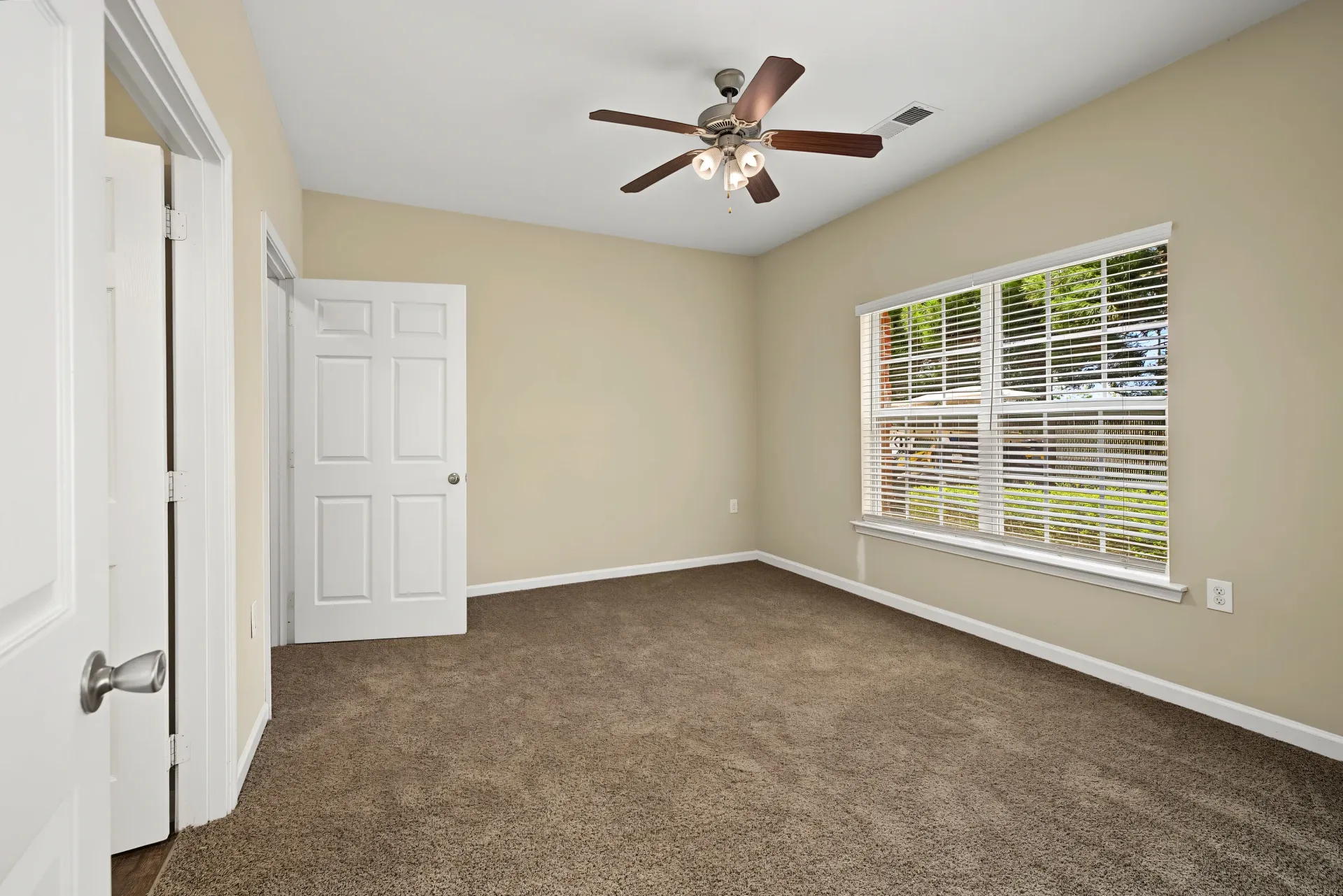 Bedroom with a ceiling fan and a window.