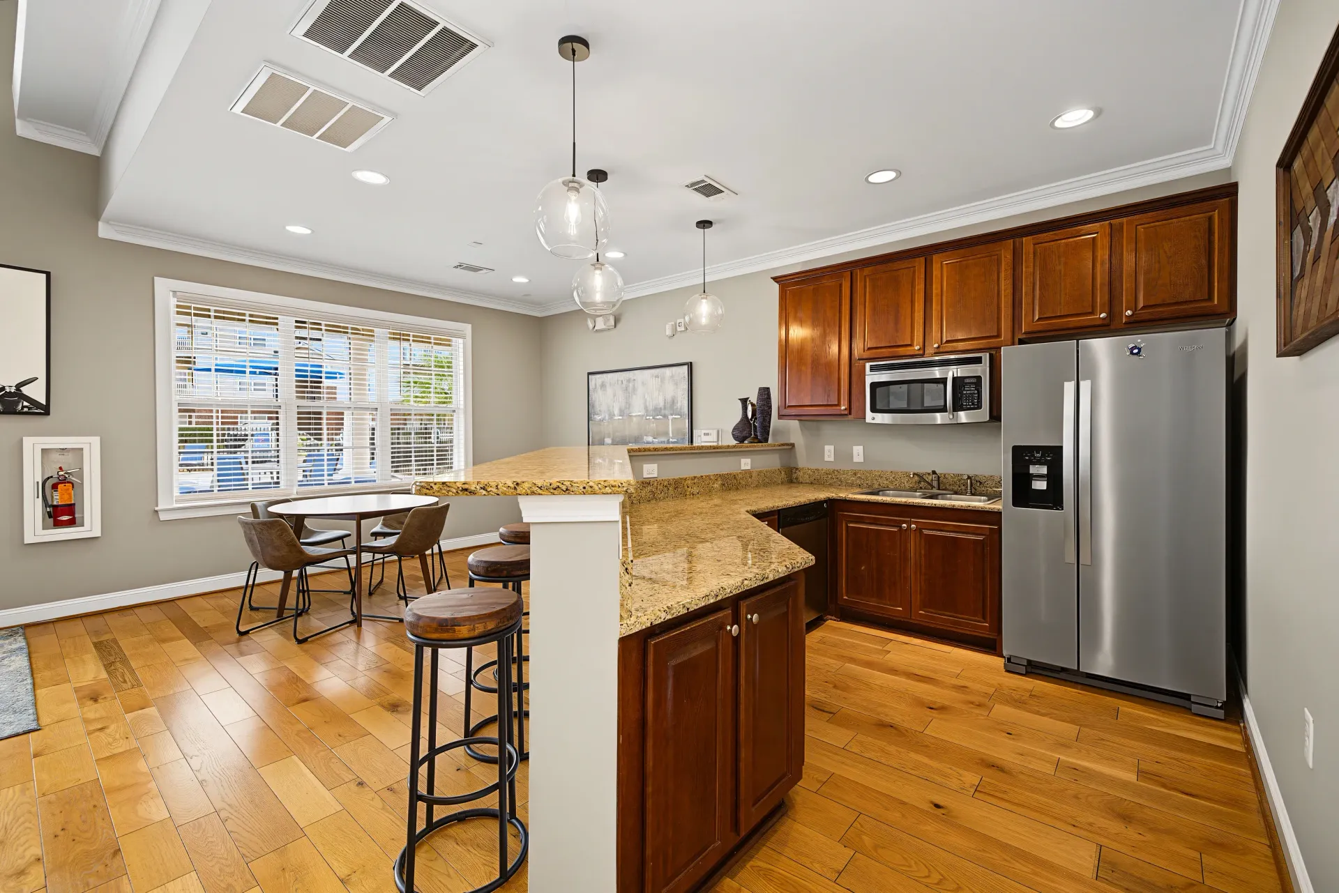Kitchen area with granite countertops, stainless steel appliances, and bar seating.