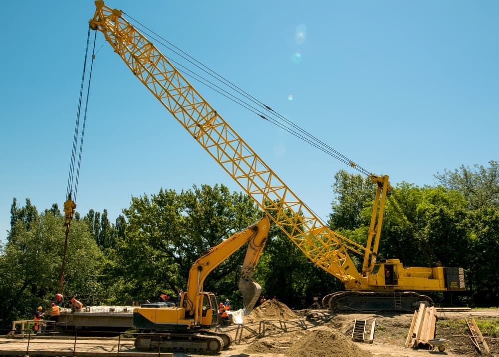 A Large Yellow Crane is Working on a Construction Site — Smithys Crane Hire in Innisfail, QLD