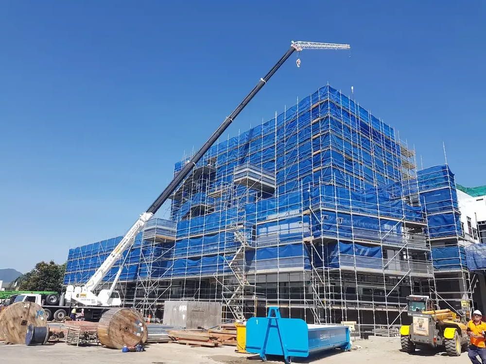 A Large Building is Being Built With Scaffolding and a Crane — Smithys Crane Hire in Mission Beach, QLD