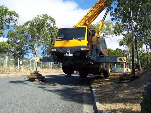Yellow Truck Being Lift On The Side Of The Road — Smithys Crane Hire in Trinity Beach, QLD