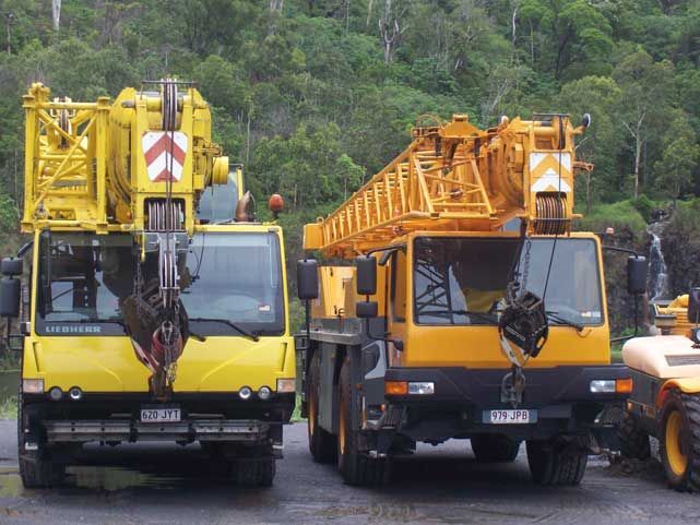Two Yellow Trucks Are Parked Next To Each Other — Smithys Crane Hire in Trinity Beach, QLD