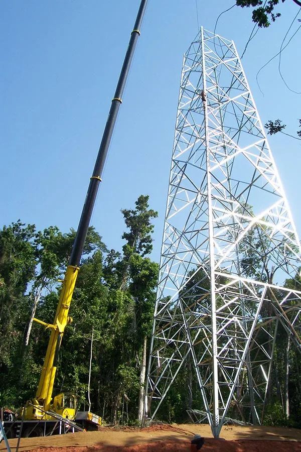 Large Yellow Crane Is Lifting A Large White Tower — Smithys Crane Hire in Trinity Beach, QLD