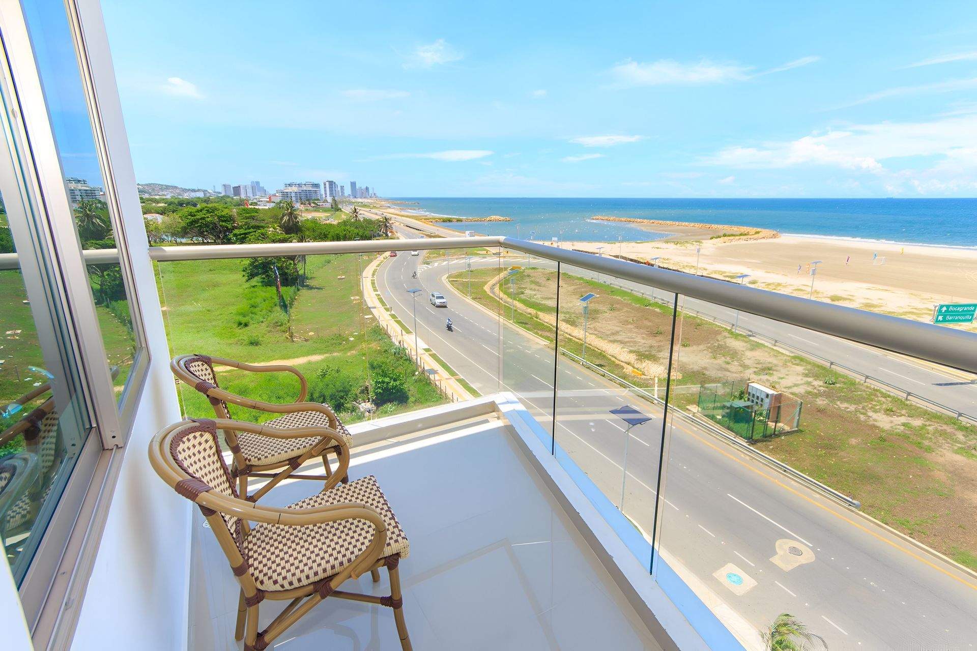 Un balcón con dos sillas y vista al mar.