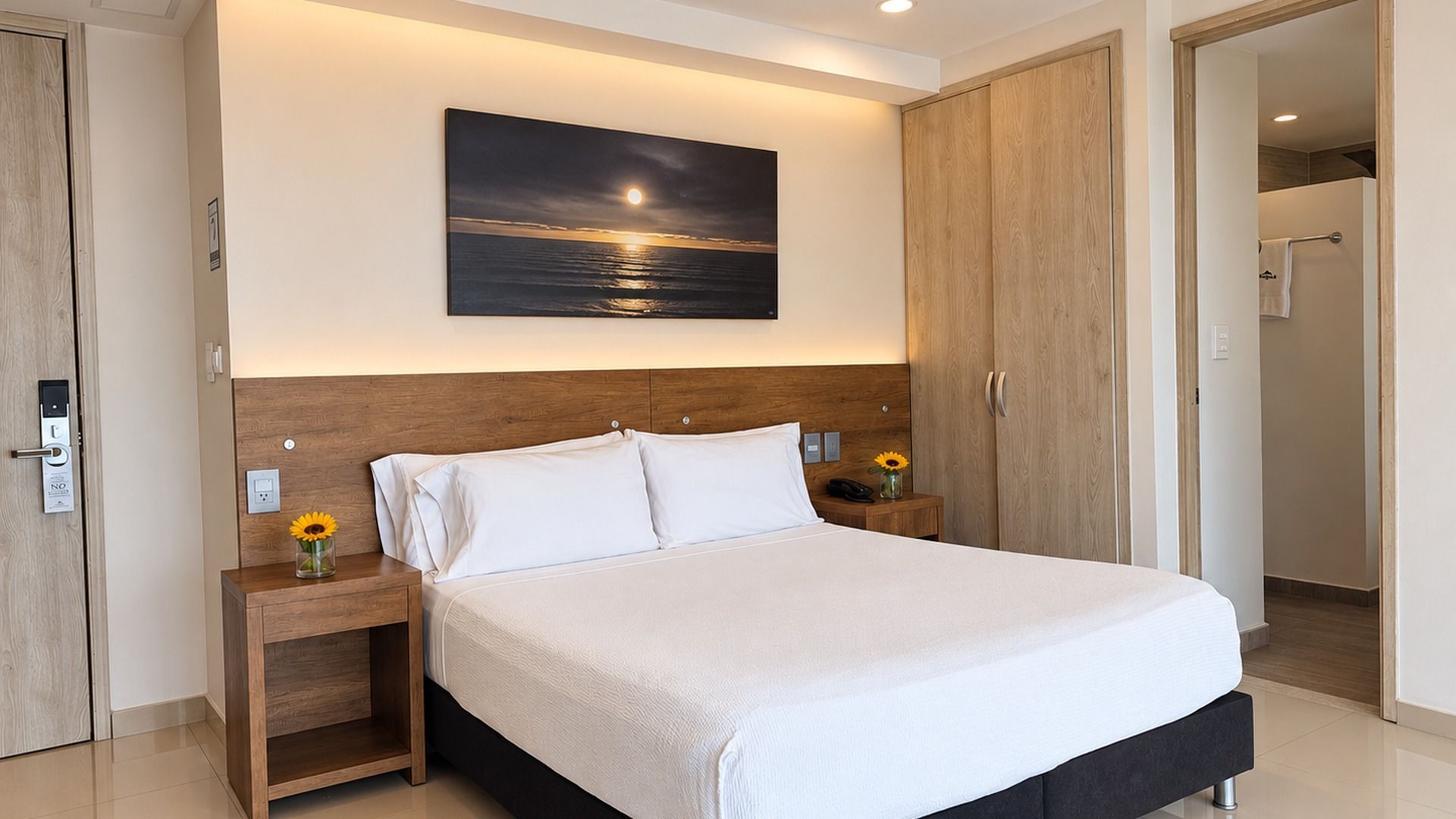 Hay una cama grande en el medio de la habitación con vista al océano.
