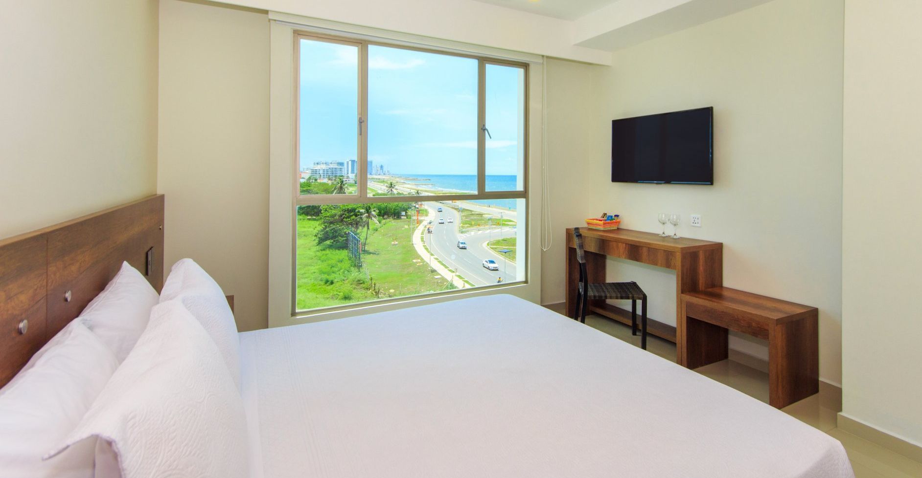 Una habitación de hotel con cama king size, escritorio y televisión.