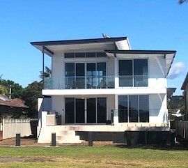 A large house with a wooden garage door and a concrete driveway.