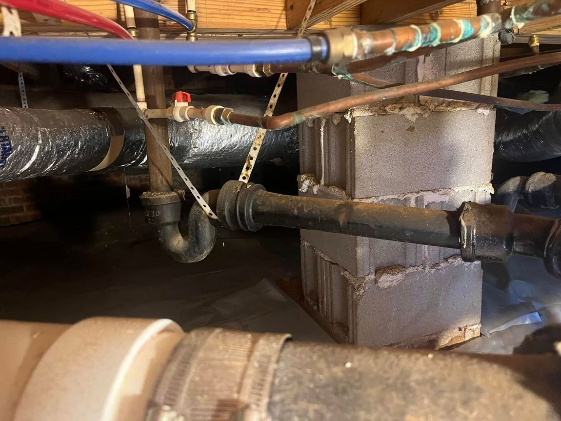 Crawlspace with exposed pipes, ducts, and a concrete support column
