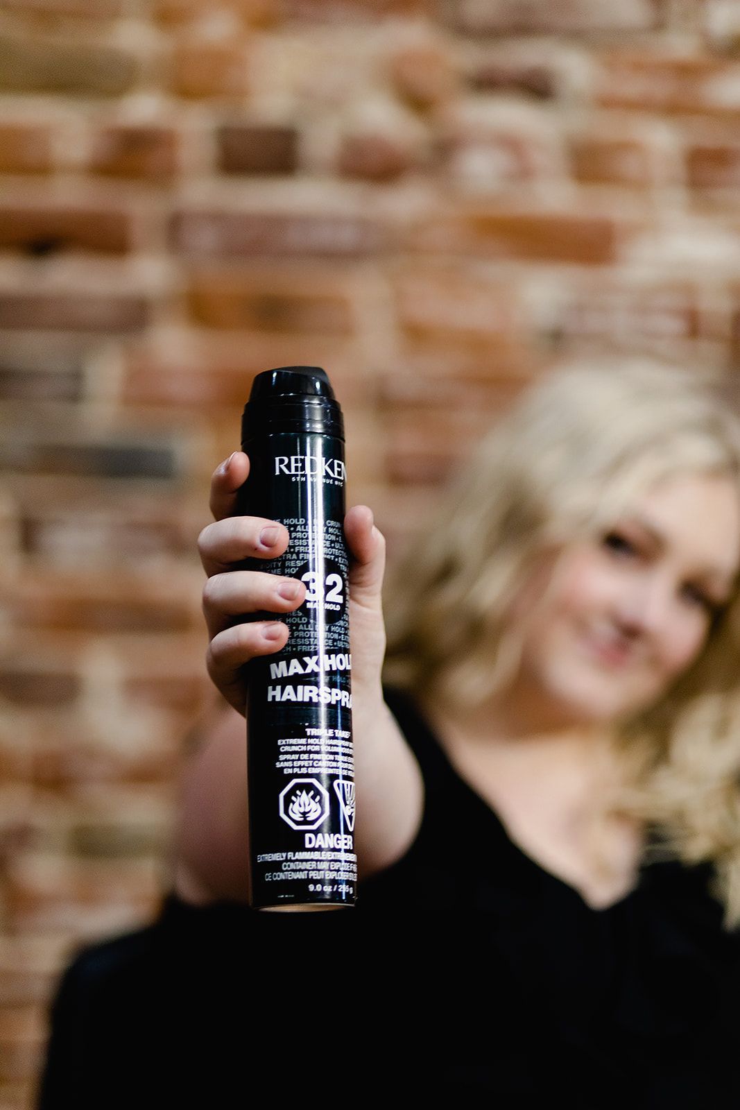 hair stylist holing up hair spray bottle