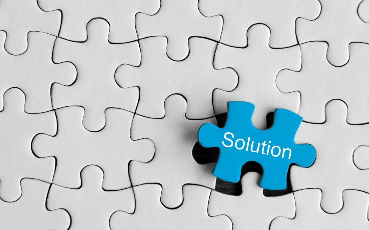 Blue puzzle piece labeled “Solution” among white jigsaw pieces