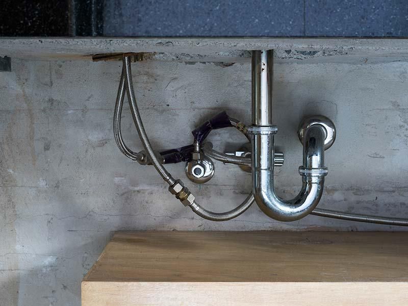 A sink with a plumbing pipe underneath it.