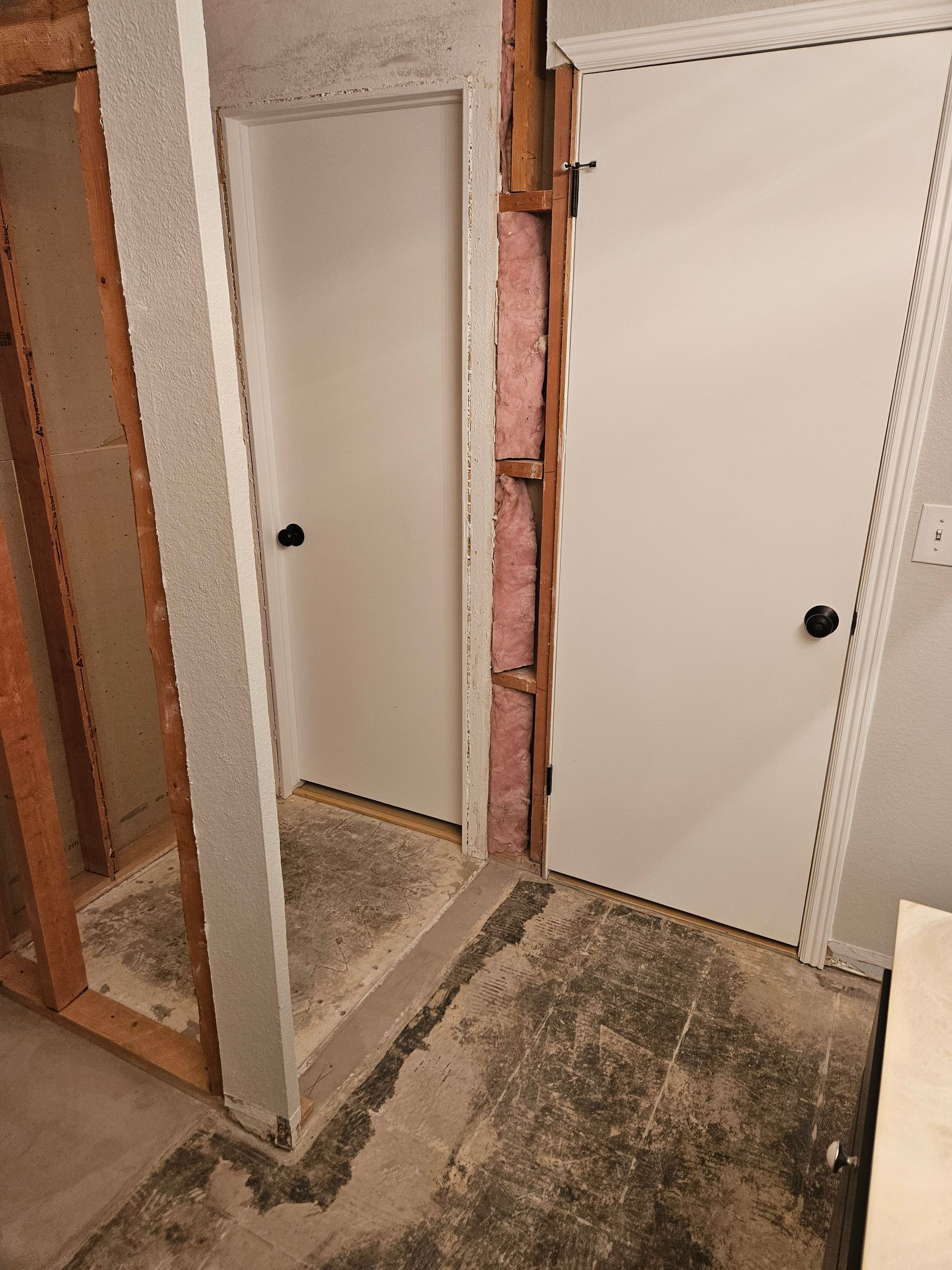 A room with a door and a mirror in it.
