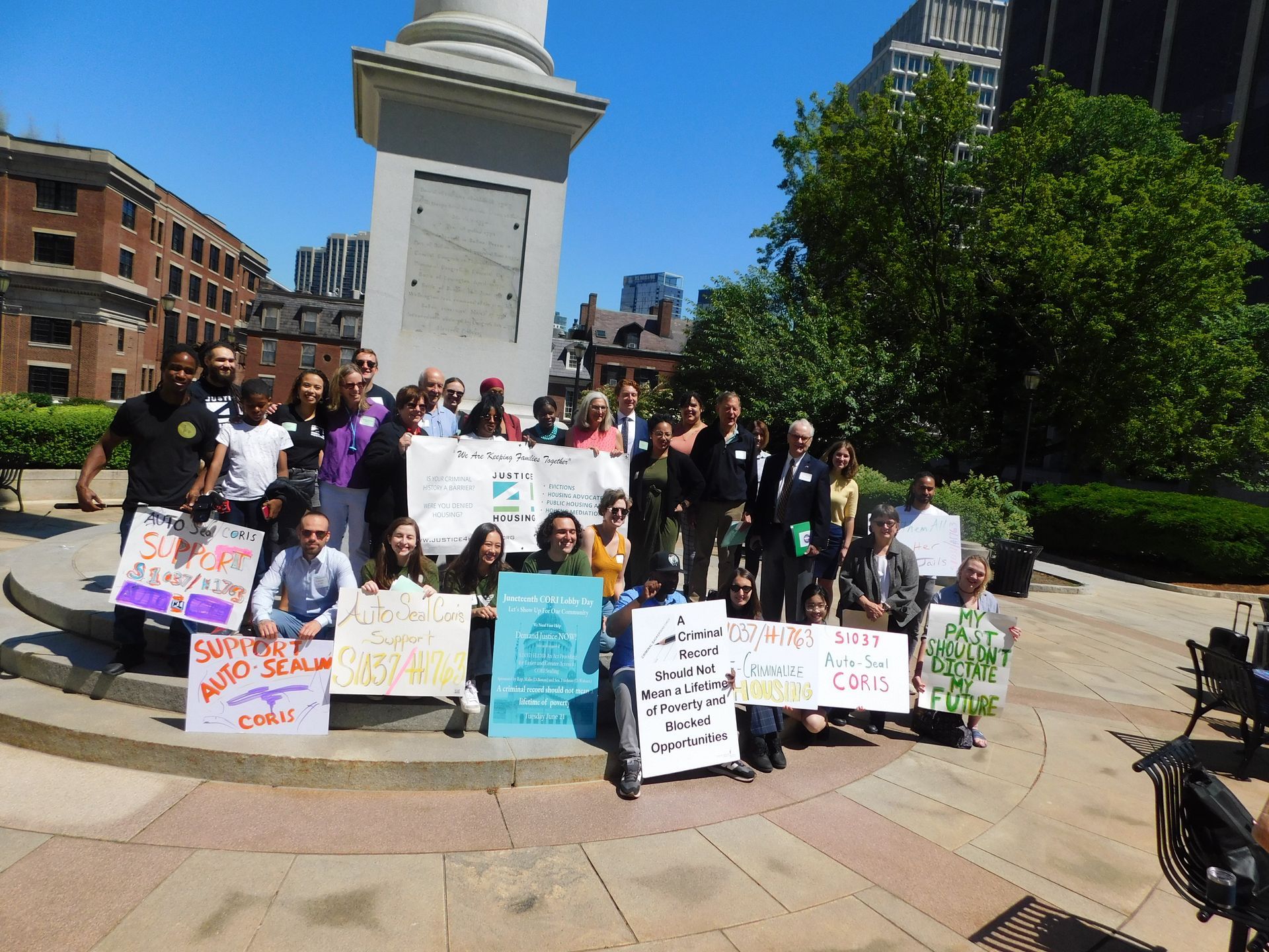 group gathers outside with signs in favor of automatically sealing CORIs once someone is eligible