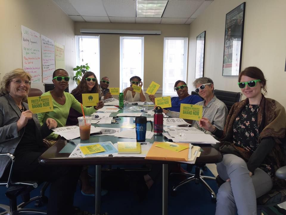 people sitting around conference table holding up yellow cards and wearing sunglasses