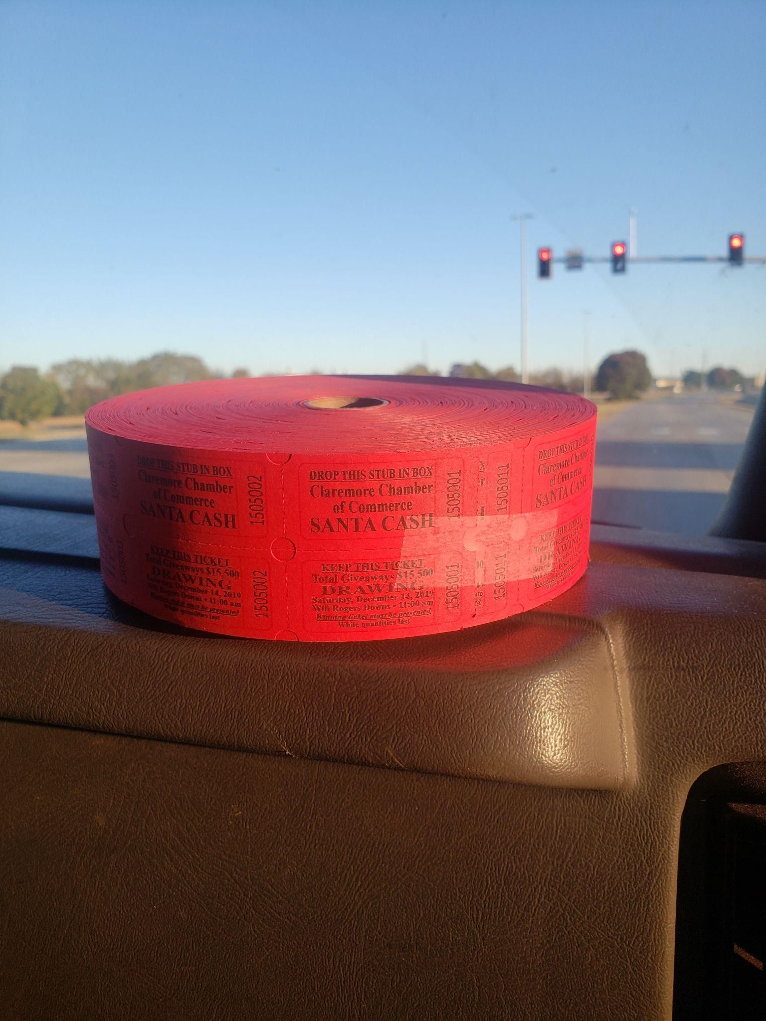 Red roll of tape on a car dashboard near a traffic light at sunset.