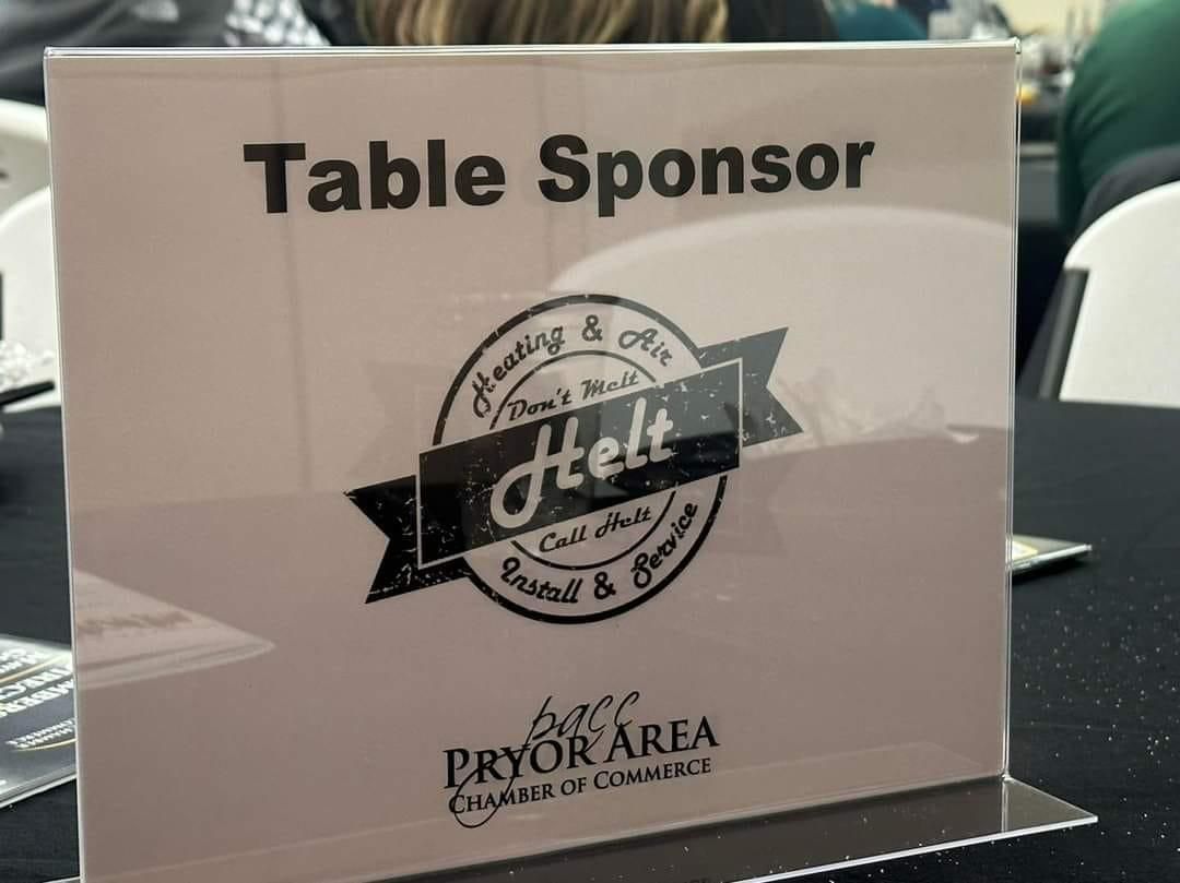 “Table Sponsor” sign with a logo on a clear acrylic stand on a table