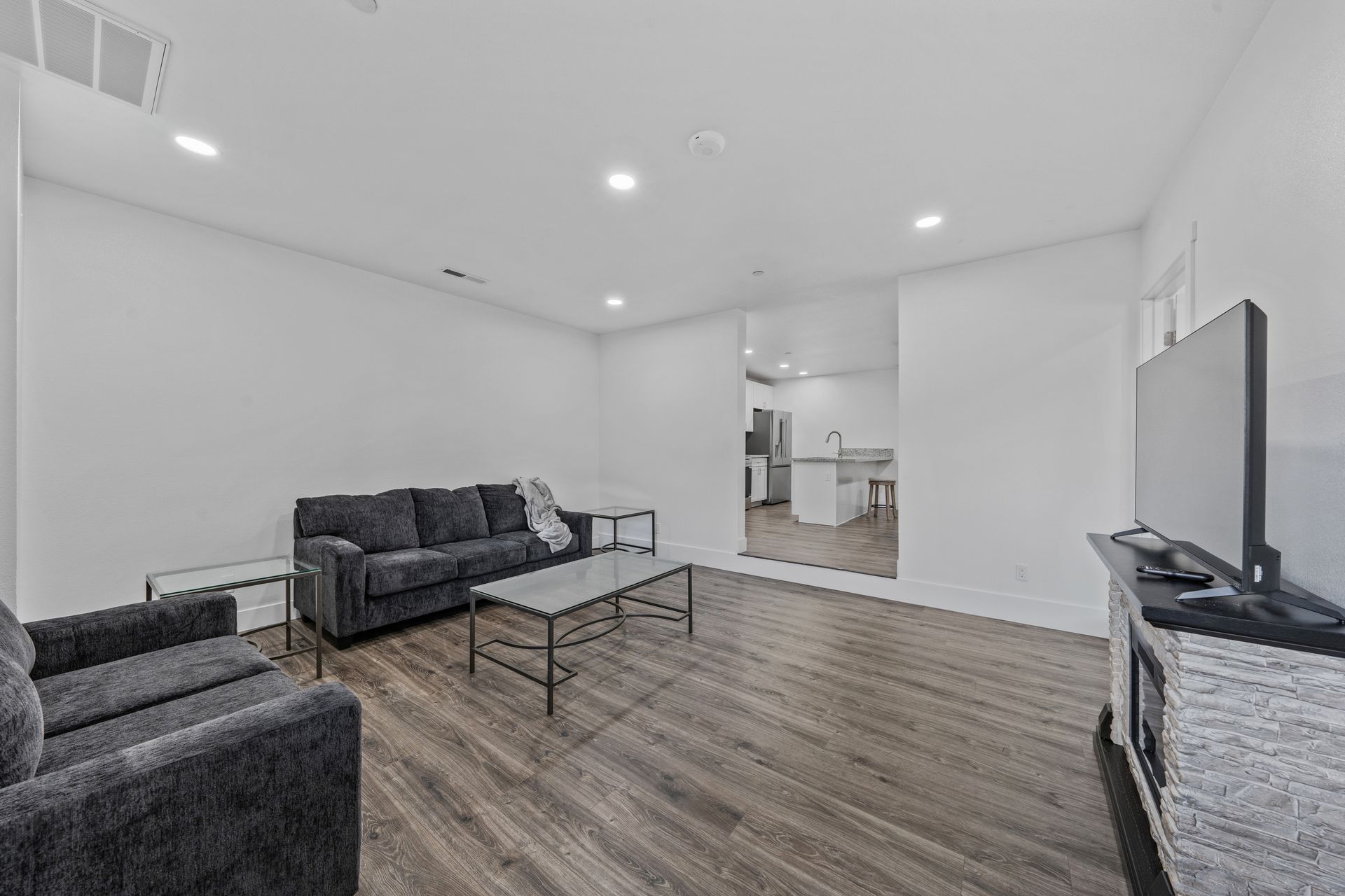 A living room with a couch , chair , coffee table and television.