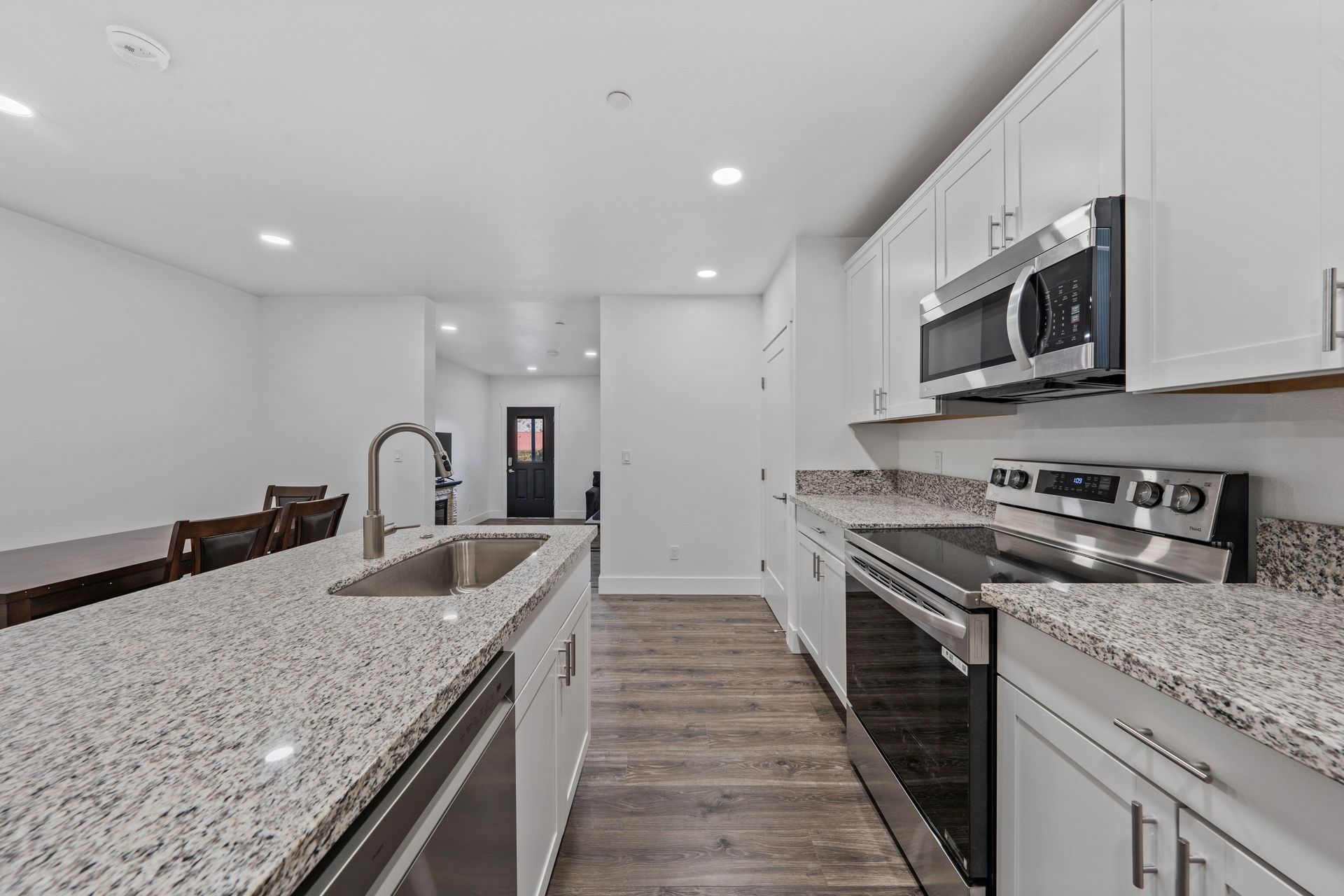 A kitchen with granite counter tops and stainless steel appliances.